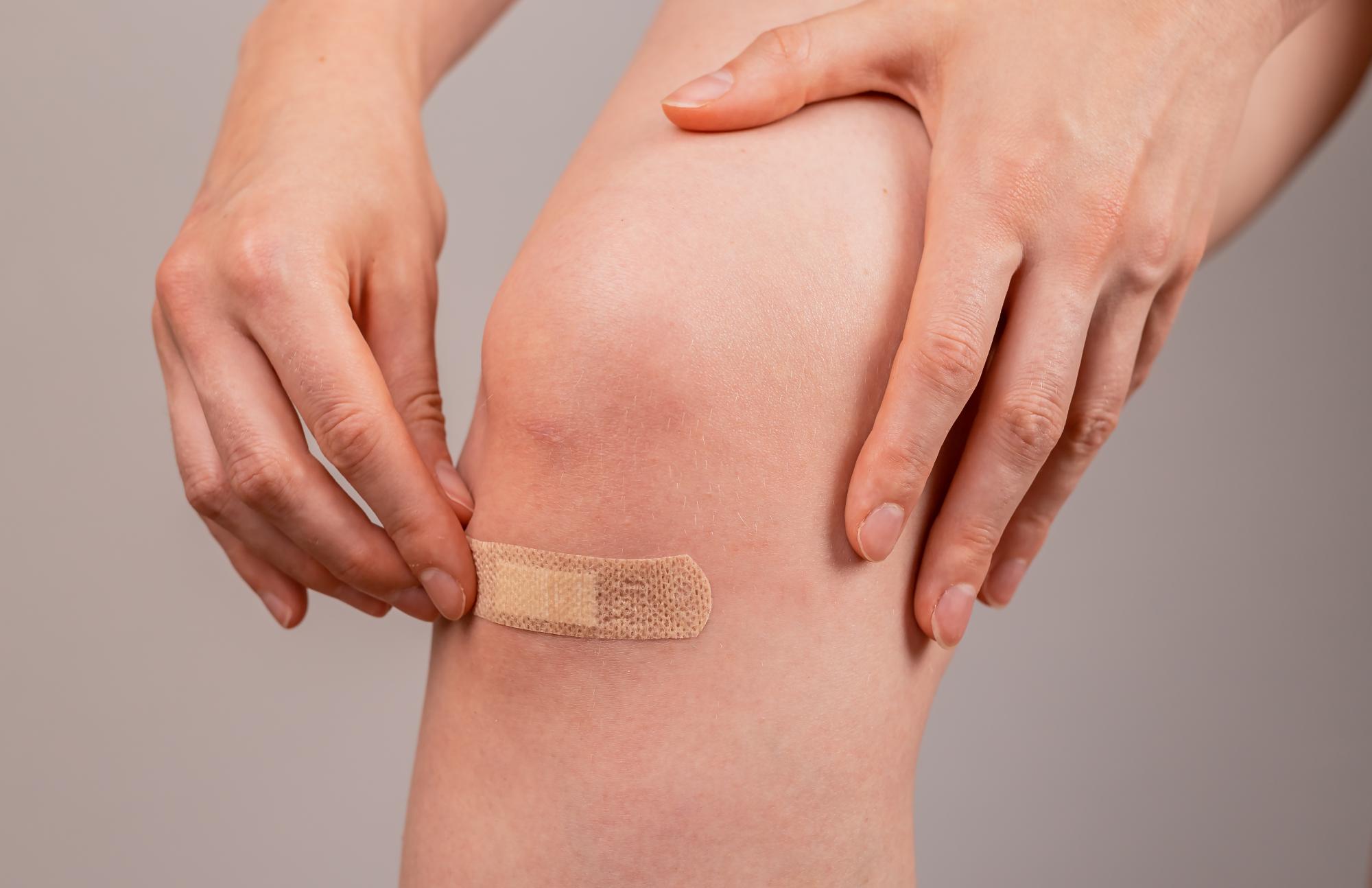 Odrenina na kolene prekrytá náplasťou. 